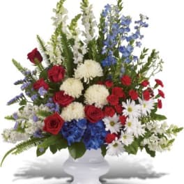 Red, white, and blue floral arrangement in a white vase