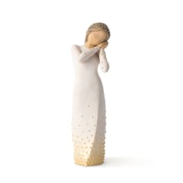 White figurine of a woman in a long dress with gold accents