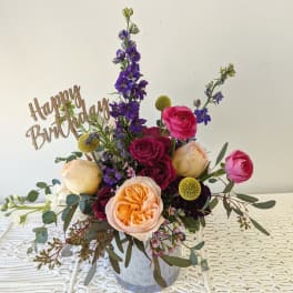 Mixed bouquet in a clear vase with a Happy Birthday sign
