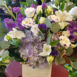 Purple and white bouquet in a square wooden box