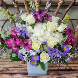 Bouquet of white and purple flowers in a light blue vase