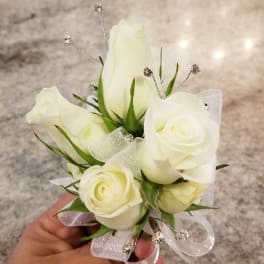 Small white rose corsage with ribbon and silver accents