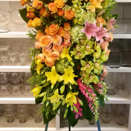 Large standing spray of yellow, orange, pink, and green flowers
