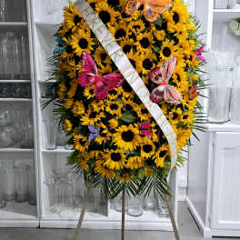 Large sunflower standing spray with a memorial ribbon and butterfly accents
