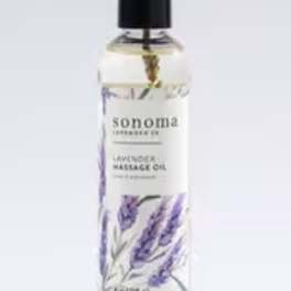 Bottle of lavender massage oil with illustrated purple lavender sprigs and a black cap