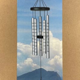 Silver wind chime hanging on a blue sky backing card