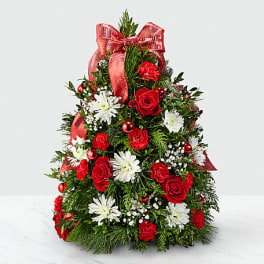 Christmas tree-shaped floral arrangement with red and white flowers and a red bow