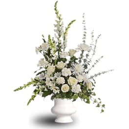 White floral arrangement in a white pedestal vase