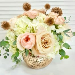 Blush roses and white hydrangeas in a speckled gold vase