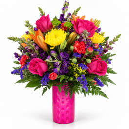 Bright mixed bouquet in a pink vase with roses, lilies, and chrysanthemums