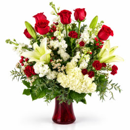 Red roses and white lilies in a red glass vase