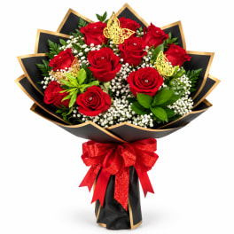 Bouquet of red roses with white filler flowers and a red ribbon
