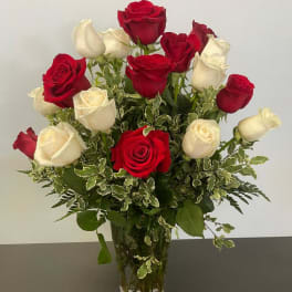 Red and white roses arranged in a clear glass vase