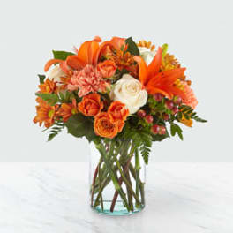 Orange and white mixed bouquet in a clear glass vase