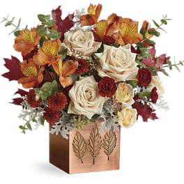 Autumn bouquet of cream roses and orange flowers in a copper vase