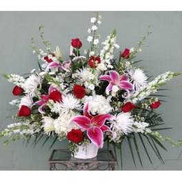Large bouquet of red and pink flowers in a white vase
