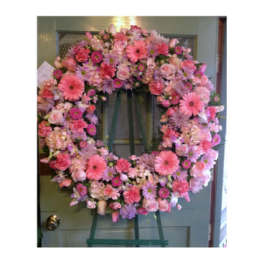 Pink floral wreath on a green easel stand