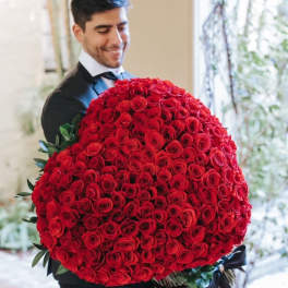 Man holding a large bouquet of red roses
