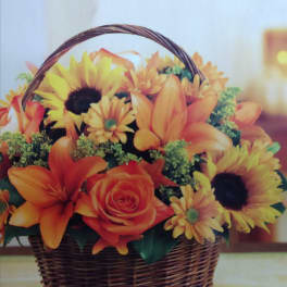 Basket of orange and yellow flowers with a wicker handle