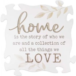 Decorative puzzle-piece sign with the word home and a love quote