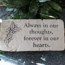 Memorial stone engraved with "Always in our thoughts, forever in our hearts."