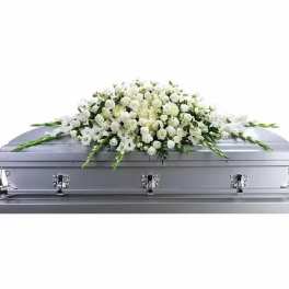 White floral casket spray on a silver casket