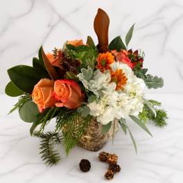 Orange roses and white chrysanthemums in a birch bark container with pinecones