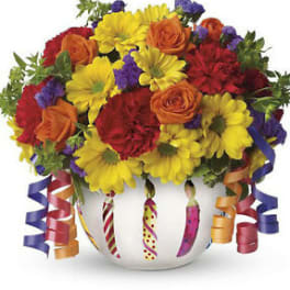 Colorful bouquet in a white vase with curled ribbon accents