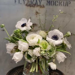 White and green floral arrangement in a clear glass vase