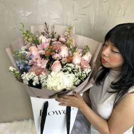 Large bouquet of pink and white flowers in mauve wrapping