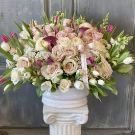 Large bouquet of pale pink and white roses with tulips in a white vase