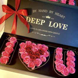 Heart-shaped rose box with pink and red roses and a red ribbon