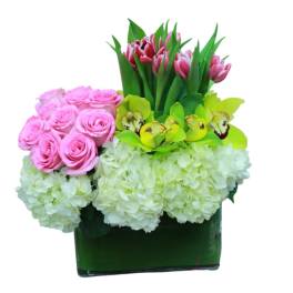 Pink roses, tulips, orchids, and white hydrangeas in a green vase