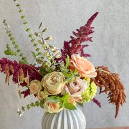 Mixed bouquet of roses and amaranthus in a white vase