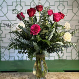 Bouquet of red, pink, and white roses in a glass vase