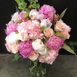 Pink and white bouquet of roses and hydrangeas in a glass vase