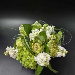 Green and white floral arrangement with hydrangeas and white blooms