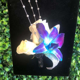 Boutonniere with white rose and blue-purple orchid on black backing