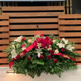Large floral spray with white lilies and red roses on a stand