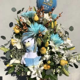 Bouquet with white lilies, yellow roses, and a baby balloon