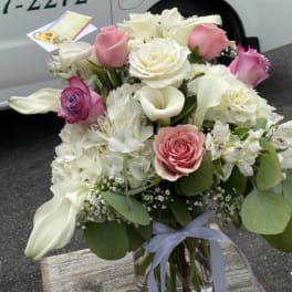 Bouquet of pink and white roses with calla lilies in a glass vase