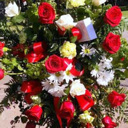 Standing floral spray with red and white roses and daisies