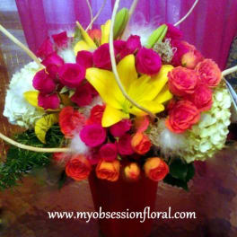Bright mixed bouquet with yellow lilies and pink roses in a red vase