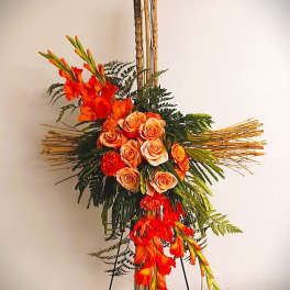 Tall floral arrangement with orange roses and gladiolus on a bamboo stand