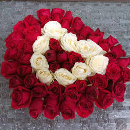 A large arrangement of red and white roses laid in a circular pattern.