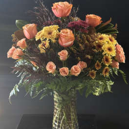 Bouquet of peach roses and yellow chrysanthemums in a clear glass vase