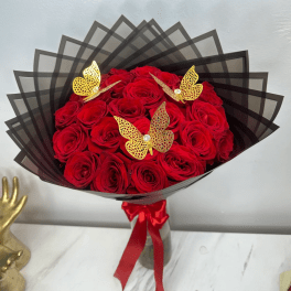 Bouquet of red roses wrapped in black paper with gold butterfly accents