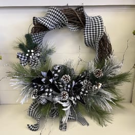 Black-and-white plaid wreath with pinecones and frosted greenery
