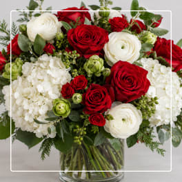 Red roses and white ranunculus in a clear glass vase
