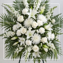 White floral standing arrangement with lilies, roses, and chrysanthemums